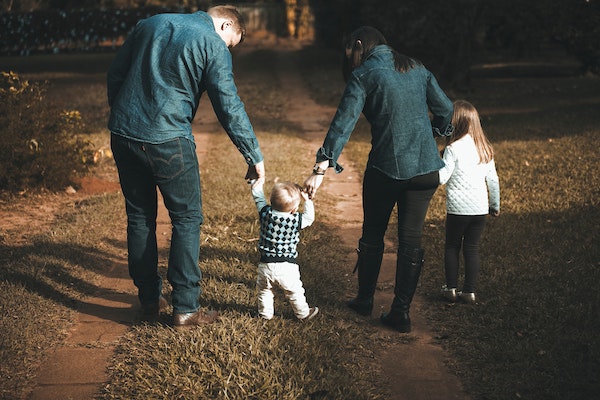 family holding hands walking in nature